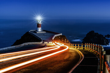 trailing car lights lead to Cabo Ortegal lighthouse at night