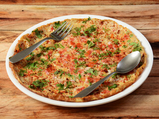 Indian Masala Egg Omelet, made with fresh vegetables tomato,onion, hot chili pepper, parsley.. served in rustic wooden background, selective focus