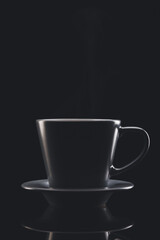 Cup of hot coffee on dark background