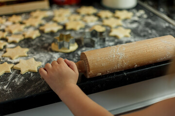 little girl bakes cookies in the form of stars. Christmas cookies.