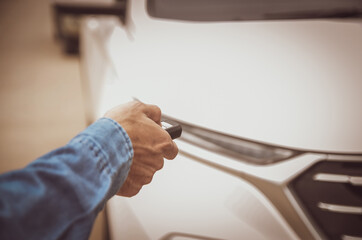 Remote control of the white car in the hand of the man was locking the car.