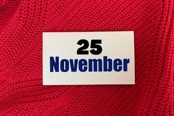 November 25 on a sticker on a red knitted background.Autumn .Calendar for November.