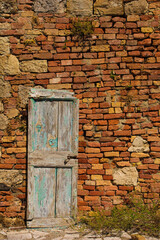 An old wooden door in a disused building in the historic medieval village of Crevole near Murlo in Siena Province, Tuscany, Italy
