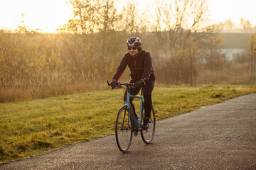 Fototapeta premium man on a blue bicycle in the morning cold season goes to work