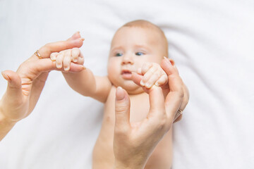The mother holds the baby's hand. Selective focus.