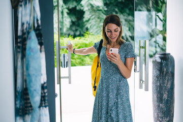 Cheerful female reading good message on smartphone