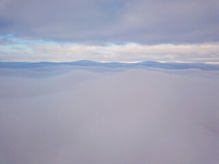High aerial flight between fog and clouds.