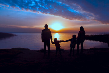 family with kids at sunset, mom, dad and kids enjoy nature