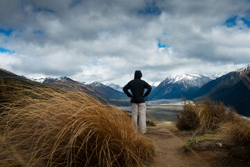 A man looking at snow-capped mountains on Bealey Spur Track in Arthur’s Pass National Park, New...
