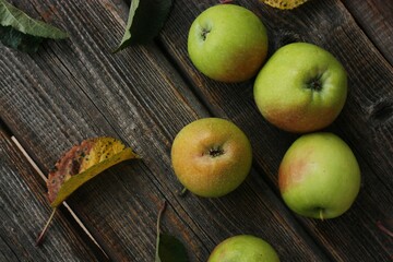 Green apples and autumn leaves on the table