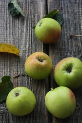 Green apples and autumn leaves on the table