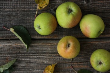 Green apples and autumn leaves on the table