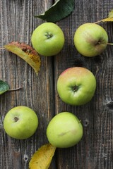 Green apples and autumn leaves on the table