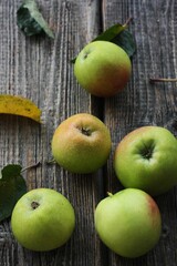 Green apples and autumn leaves on the table