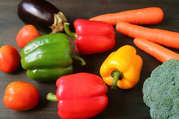 Multi-color assorted fresh vegetables scattered on black wooden background	