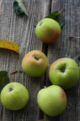 Green apples and autumn leaves on the table