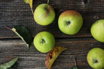 Green apples and autumn leaves on the table