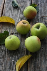 Green apples and autumn leaves on the table