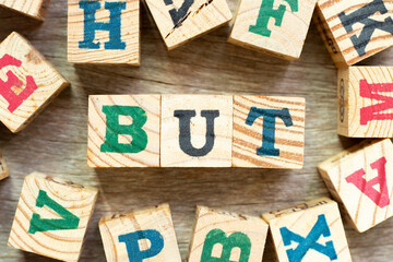Alphabet letter block in word but with another on wood background - obrazy, fototapety, plakaty