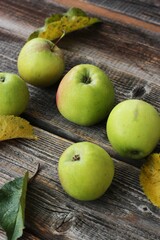 Green apples and autumn leaves on the table