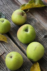 Green apples and autumn leaves on the table