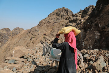 Women bring their food and drink needs through rugged mountain roads because  in the  west of Taiz...