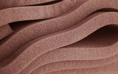 curved folds of brown spongy foam material 