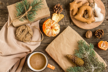 Obraz na płótnie Canvas New Year's composition. Gingerbreads, gift wrapped in paper and Christmas decorations on a wooden background. Christmas, winter, new year concept. Flat lay, top view