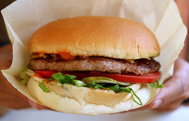 Closeup a delectable big hamburger in wrapping paper