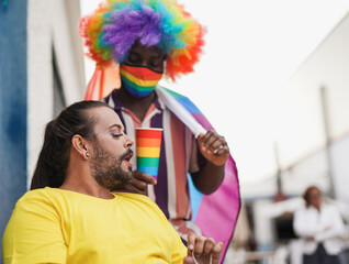 Obraz na płótnie Canvas Gay men at gay pride parade - Drag queen and african gay man with lgbt rainbow flag