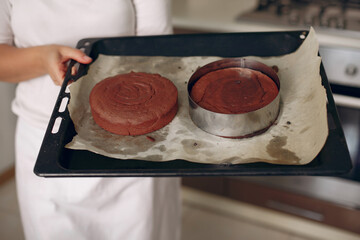 Chef in white clothes prepares a chocolate cake. Lady is preparing dessert. Woman bakes a cake.
