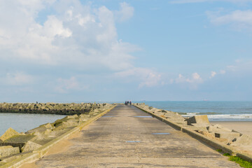 Panoramic view of a curvy footpath going towards a lighthouse at Scheveningen Beach located in The Hague, Netherlands