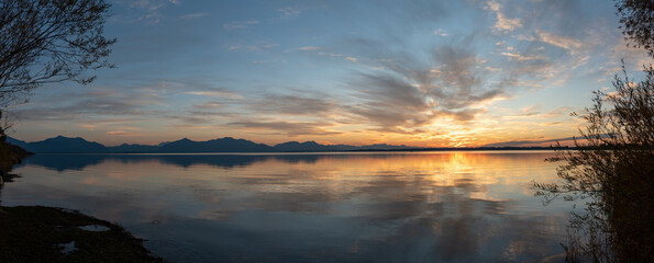 Sonnenuntergang am Chiemsee mit Wolken , Spieglung und Bergen