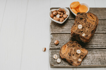 bread with dried fruits, nuts, dried apricots on a wooden Board on top copyspace