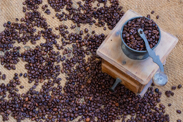 Obraz na płótnie Canvas coffee grinder with coffee beans on a jute background 