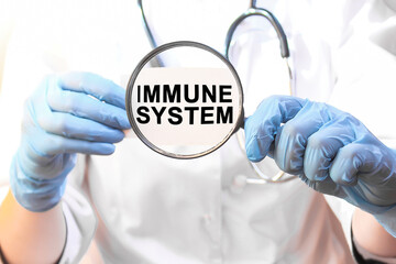 The doctor's blue - gloved hands show the word IMMUNE SYSTEM - . a gloved hand on a white background. Medical concept. the medicine