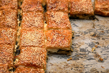 Burekas. Puff pastry pies with spinach with spinach, salted cheese, and sesame