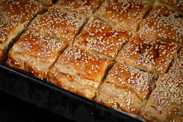 Burekas. Puff pastry pies with spinach with spinach, salted cheese, and sesame