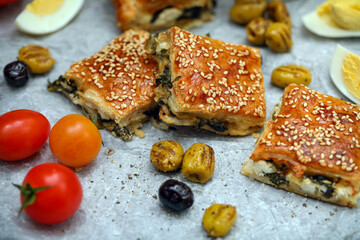 Burekas. Puff pastry pies with spinach with spinach, salted cheese, and sesame