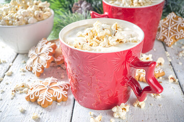 Popcorn latte Coffee Mug. Trendy hot drink, latte with salted cheese popcorn, with winter Christmas decoration, white wooden background copy space