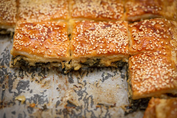 Burekas. Puff pastry pies with spinach with spinach, salted cheese, and sesame