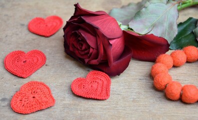 Velvet red rose with hearsts on wooden background romantyczne tło z różą i serduszkami © Anna