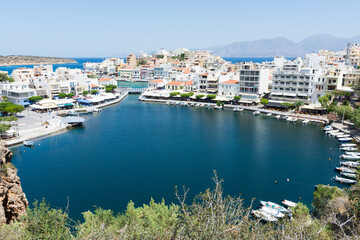 Agios Nikolaos. Crete. Buildings on the shore of Voulismeni Lake and boats at the pier