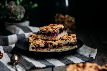 shortcrust pastry pie with black currants and tea on a dark background
