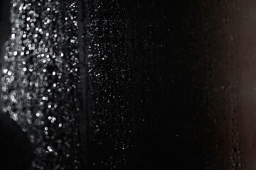 Glistening drops on the glass. Silvery drops in the bathroom. Transparent fog on the glass in drops, and the pattern of them.