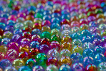 Fototapeta na wymiar Set of transparent, shiny and many-coloured beads looking like soap bubbles. Seed beads for use in necklaces and bracelets.