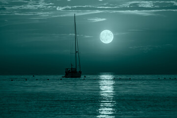Beautiful night Adriatic sea, yacht and full moon, Croatia. Night seascape. Trendy banner toned in...
