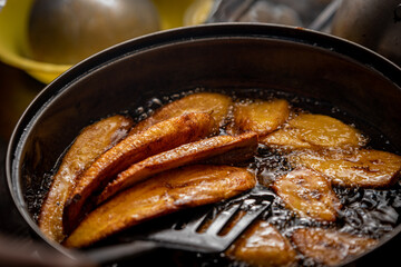 A close up shot of plantain being fried in oil 