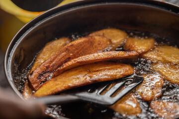 A close up shot of plantain being fried in oil  - obrazy, fototapety, plakaty