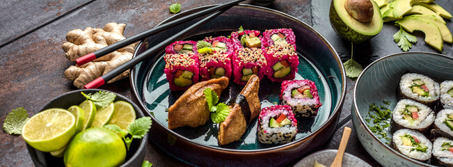 Delicious rolls, sushi and maki on a dark wooden Board with chopsticks. On black rustic background